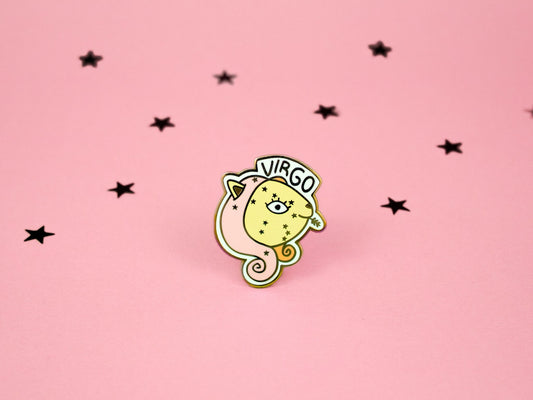 enamel pin of virgo cat in pink yellow and orange colours with a wheat stalk in it&#39;s mouth and the virgo constellation on its face and the word virgo above