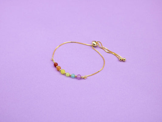 gold adjustable bracelet with gemstone beads in the colours of the LGBTQIA flag