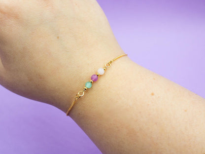 gold bracelet with gemstone beads in the colours of the bisexual flag