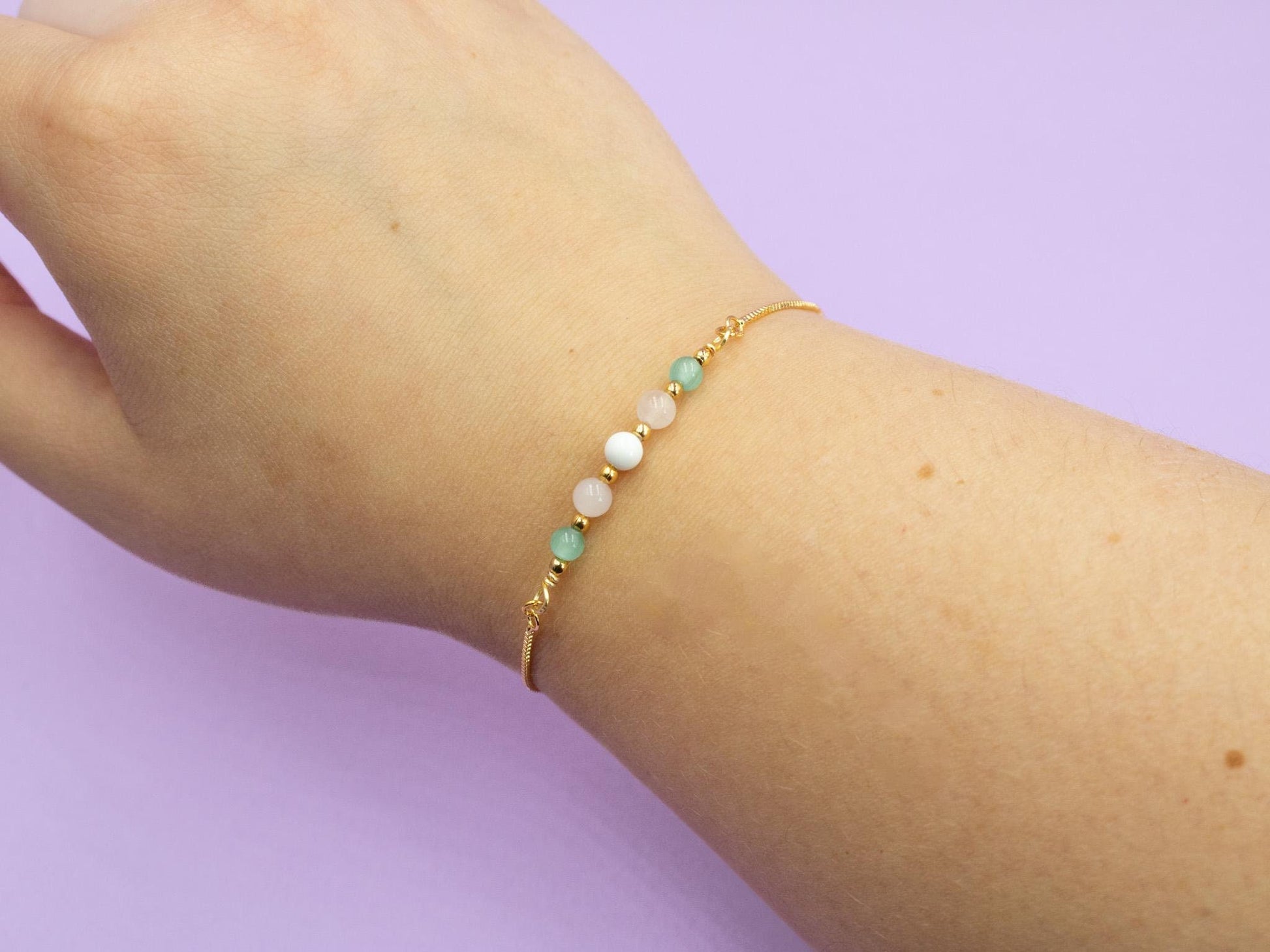 gold bracelet with gemstone beads in the colours of the transgender pride flag