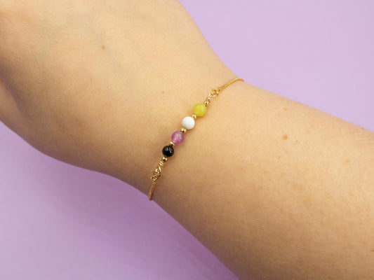 gold bracelet with gemstones beads in the colours of the nonbinary flag