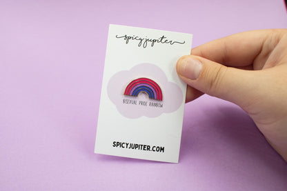 hard enamel pin in the shape of a rainbow with the stripes made up of the colours of the bisexual flag